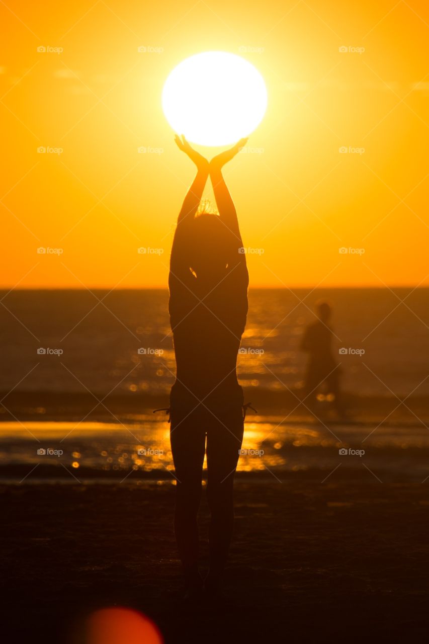 My little girl holding the sun during an magnificent sunset
