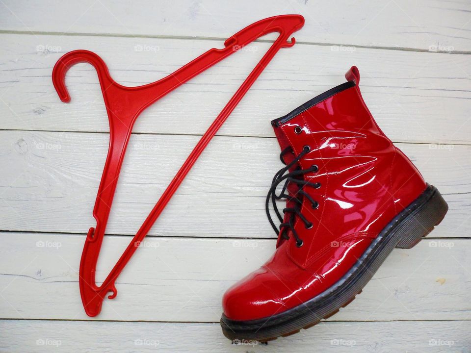 red women's shoe and red hanger on a white background