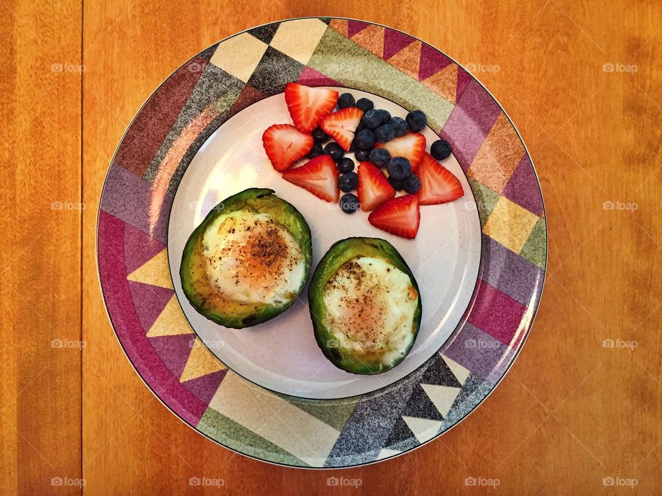 Egg-ceptional. A homemade breakfast which consisted of baked eggs in avocados and a strawberry and blueberry fruit salad.
