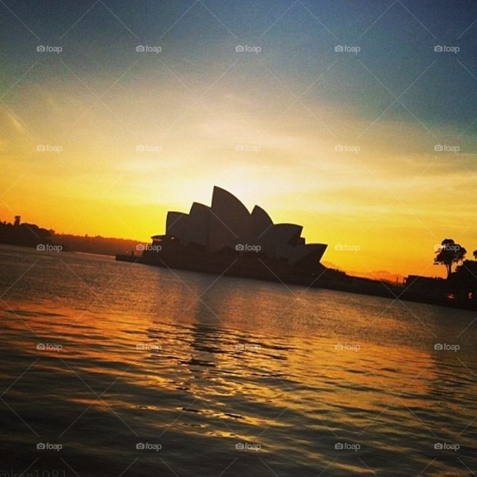 sunset sun water building by itsAus