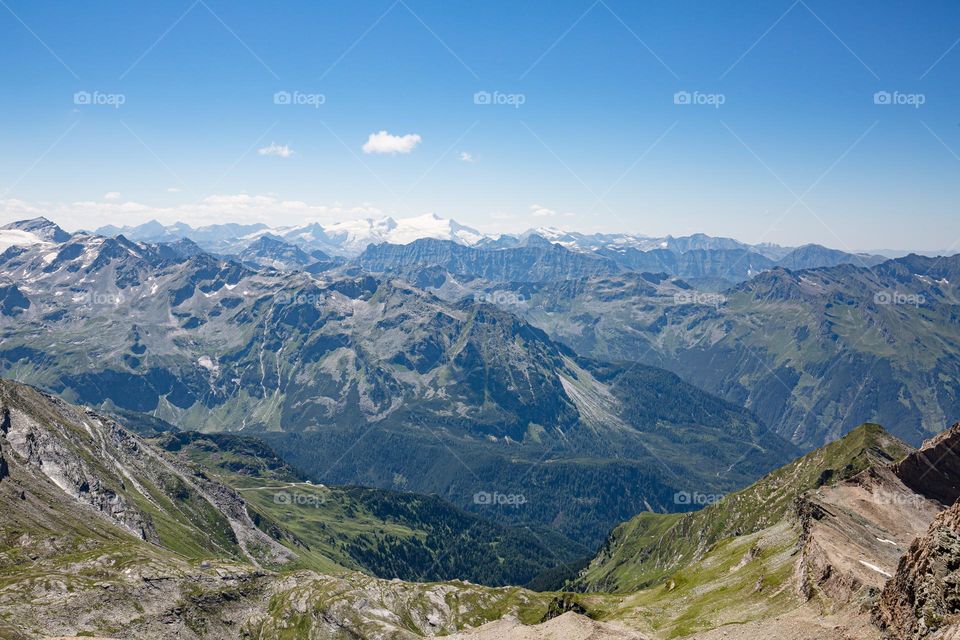 Panoramic view of mountain peaks in Austria with blue sky from the mountain Kitzsteinhorn 