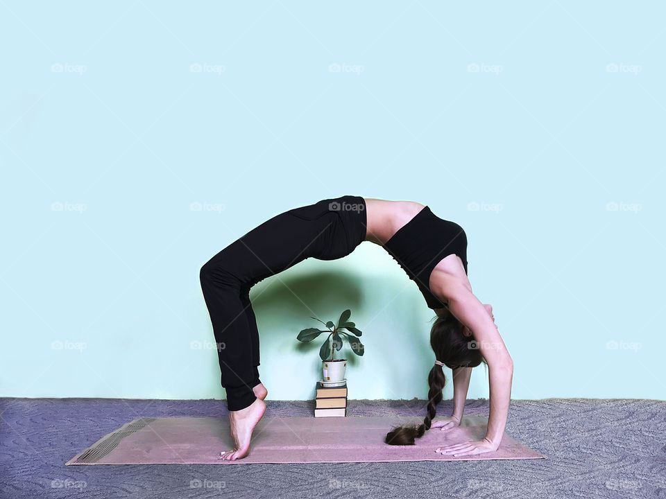 Young woman with long hair doing yoga at home 