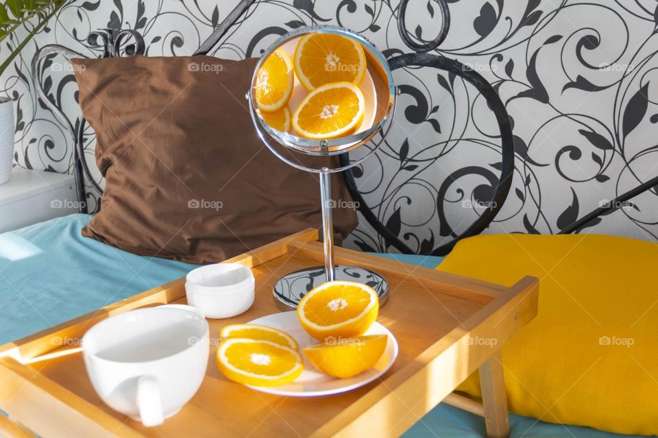 Bright oranges are reflected in the mirror and lie on the coffee table.