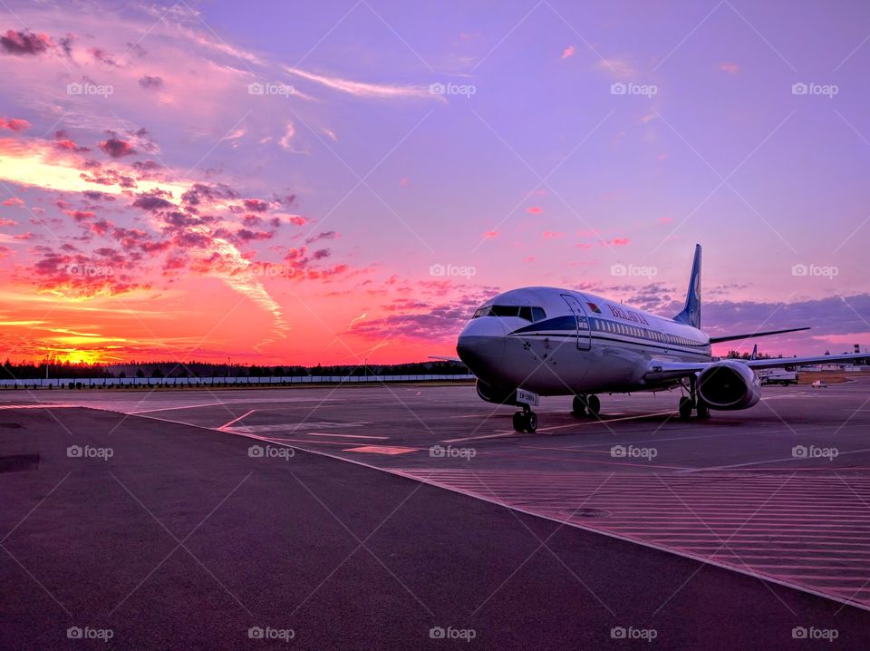 Beautiful sunrise in airport and Belavia jet.