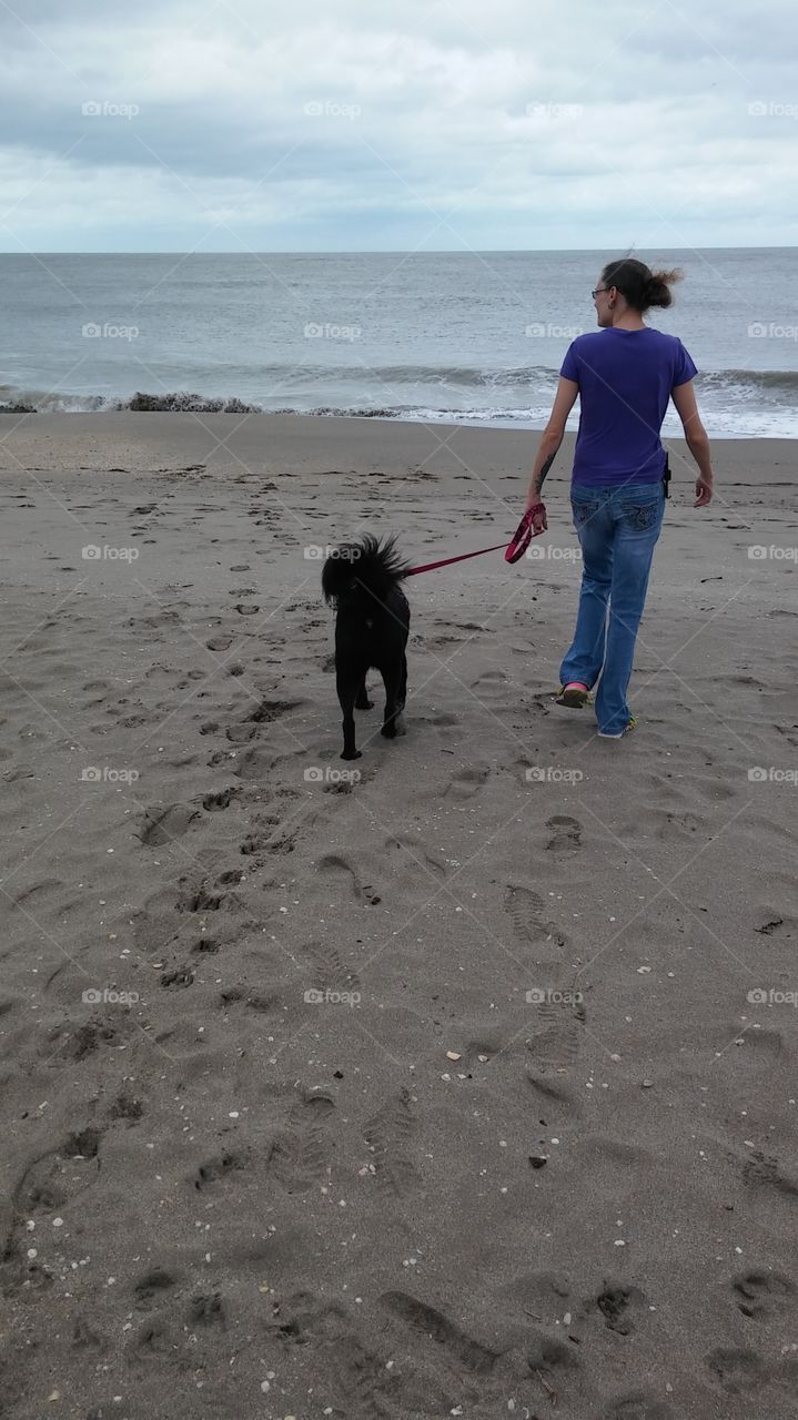 Dog and woman enjoying the beach.
