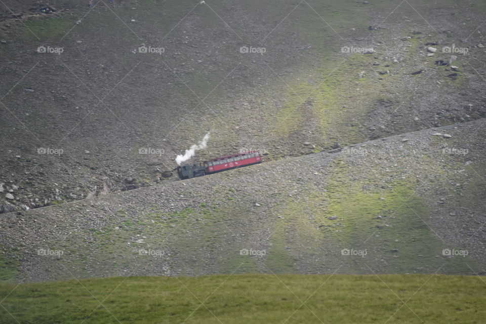 Steam train traveling down mount Snowdonia Wales