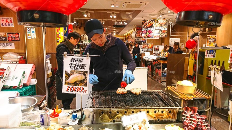 Some people is grilling a oyster.
