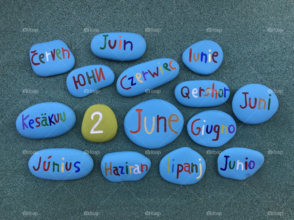 2 June, calendar date with colored stones over green sand