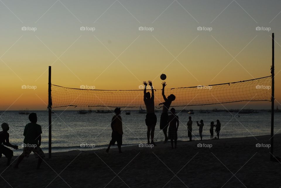 Volleyball at the beach at sunset 