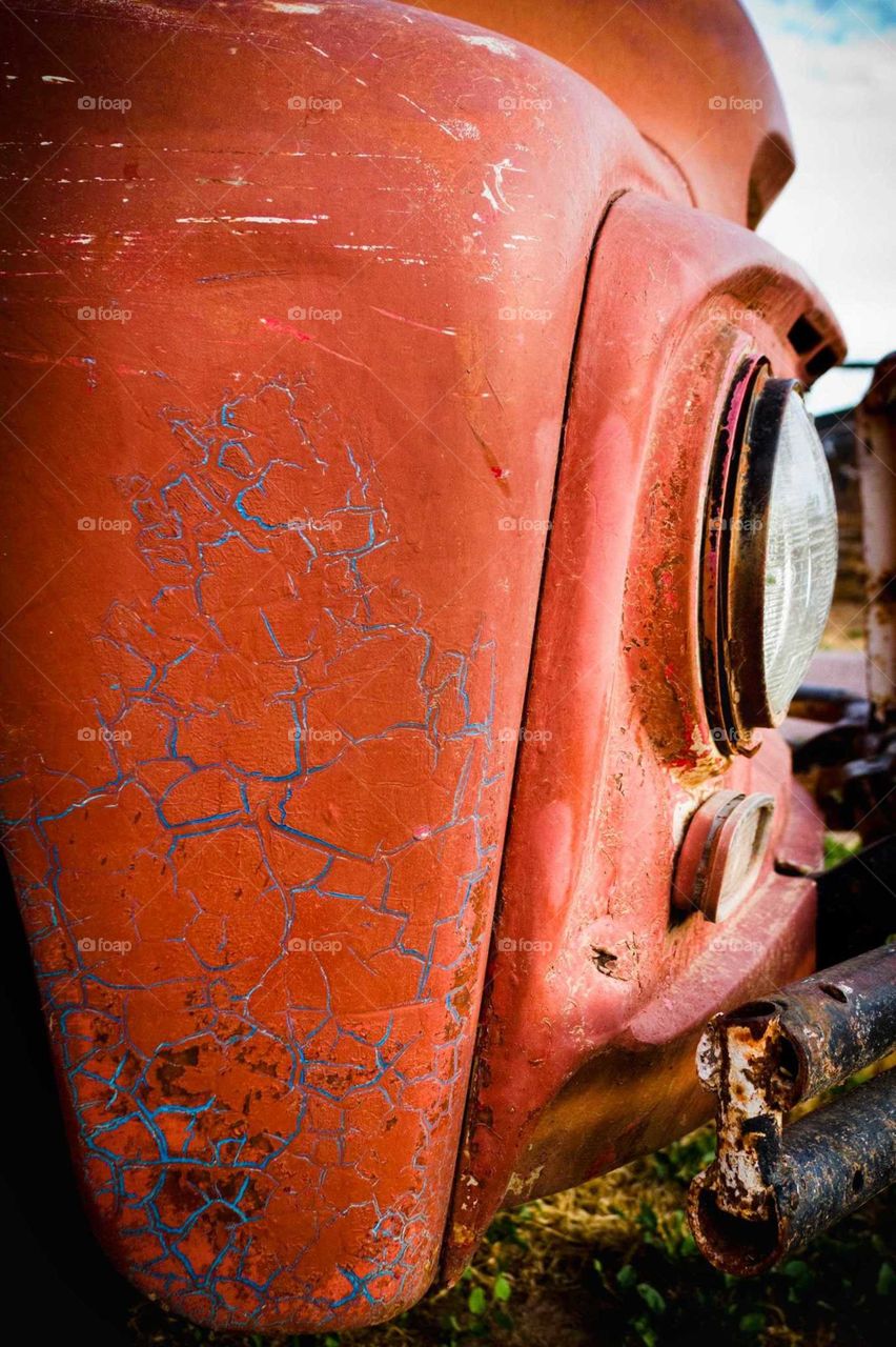 Close-up of a rusty truck with blue veins starting to show.