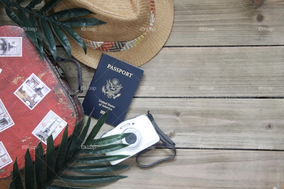 Travel items flat lay with camera passport and hat