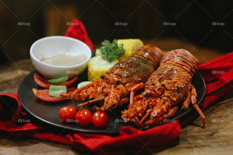 Lobster creamy garlic Lobster served with corn, tomatoes, lemon wedges, cherry and Asian-style creamy garlic sauce.