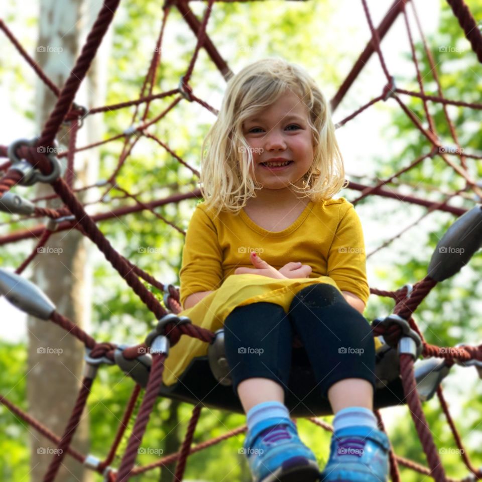 Beautiful child playing on a climbing playground 