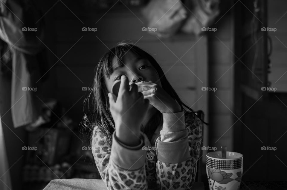 A little girl lost in thought on the breakfast table