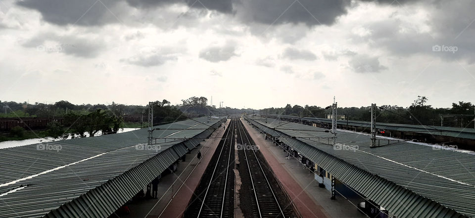 View from the footbridge showing the overall railway track ,platform canopies.Photo clicked on a cloudy weather.
