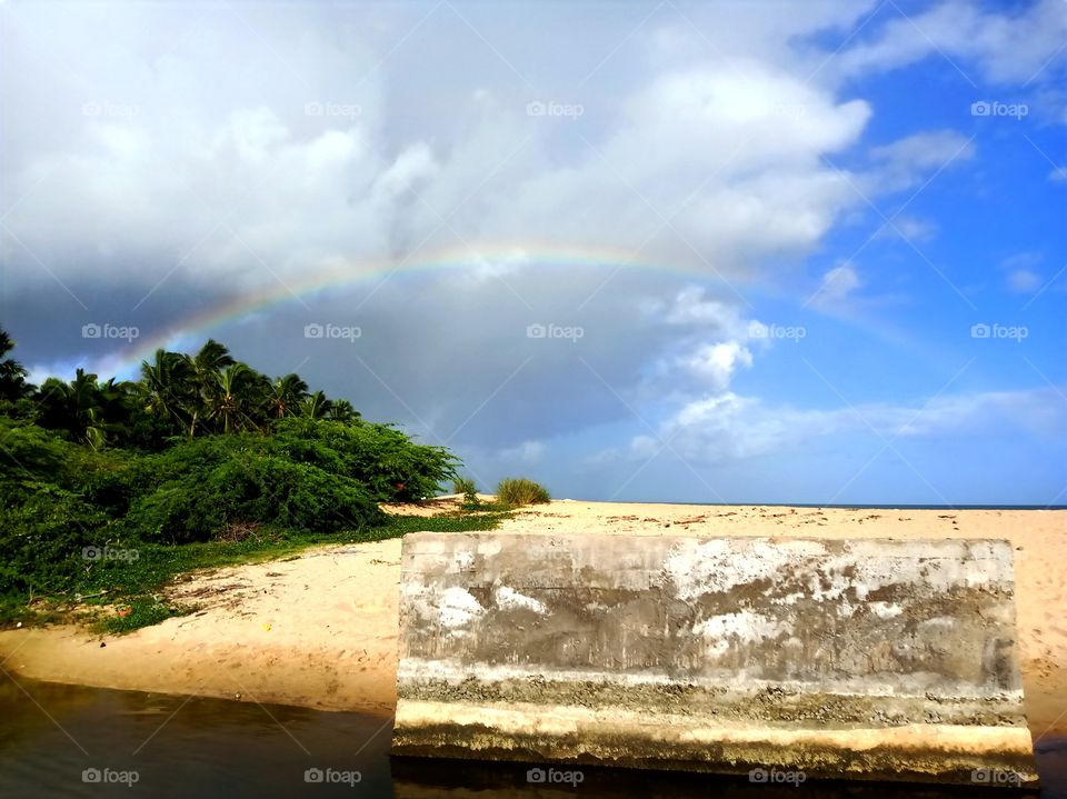 Rainbow in the blue and cloudy sky