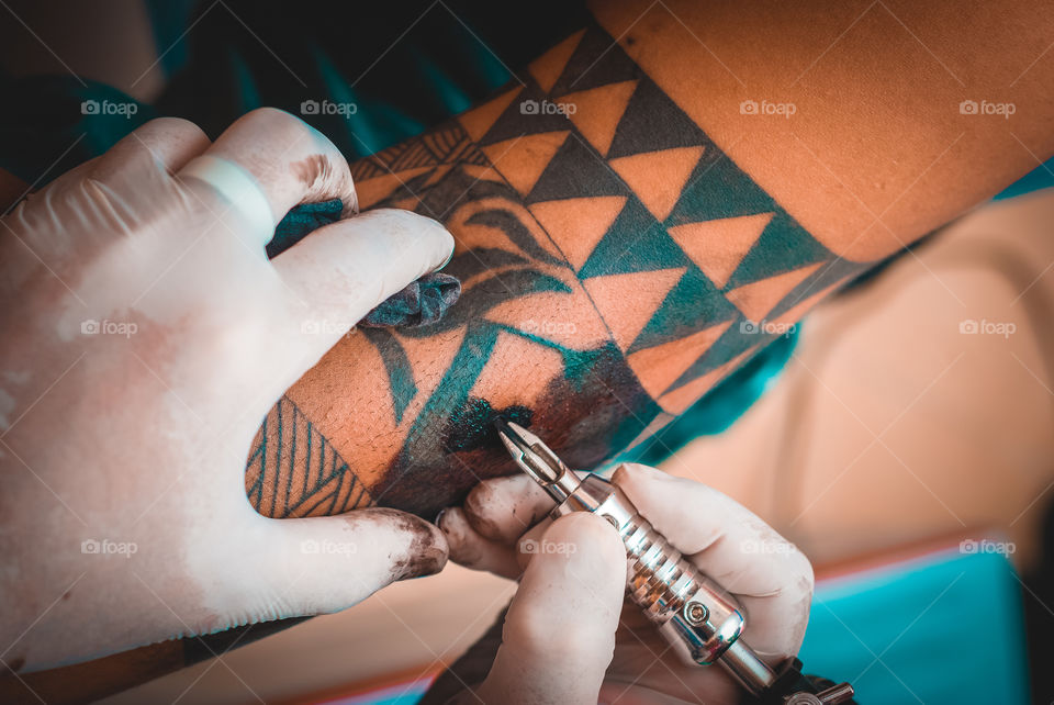 Close up of a tattoo artist performing his art.