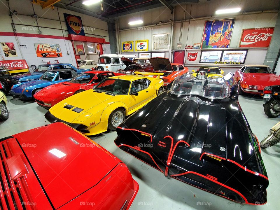 Exotic cars including the Batmobile sit in a exclusive garage featuring millions of dollars worth of exotics