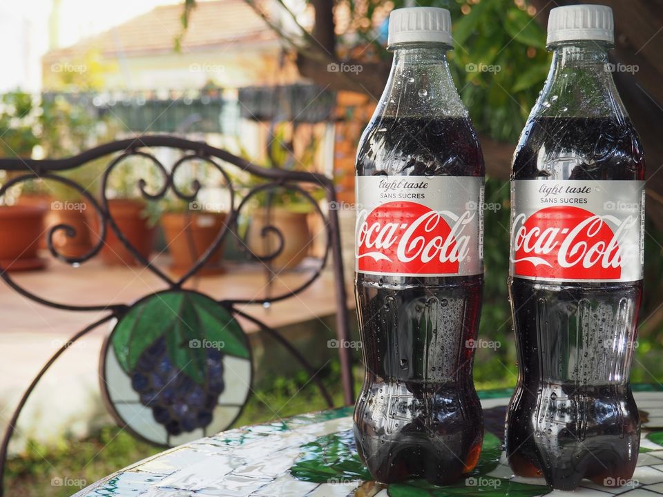 Diet Coca Cola bottles on garden table.