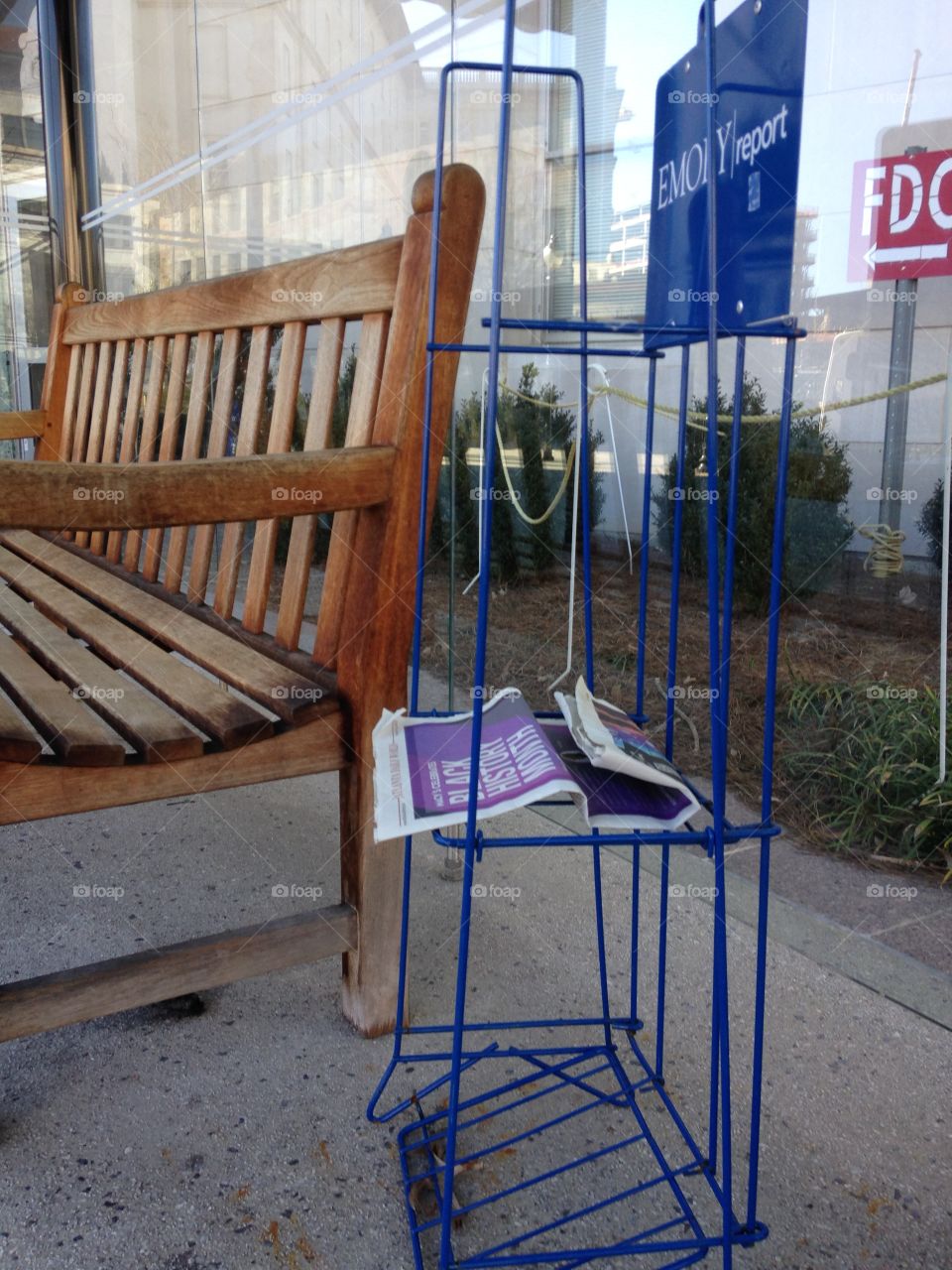 Almost empty newsstand beside a bench at a bus stop