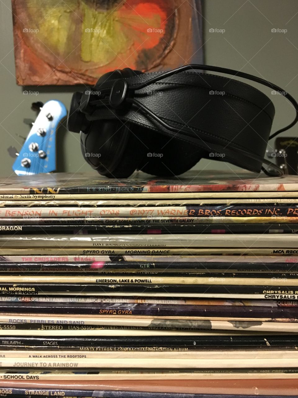 Vinyl, record albums in a stack with headphones in a studio