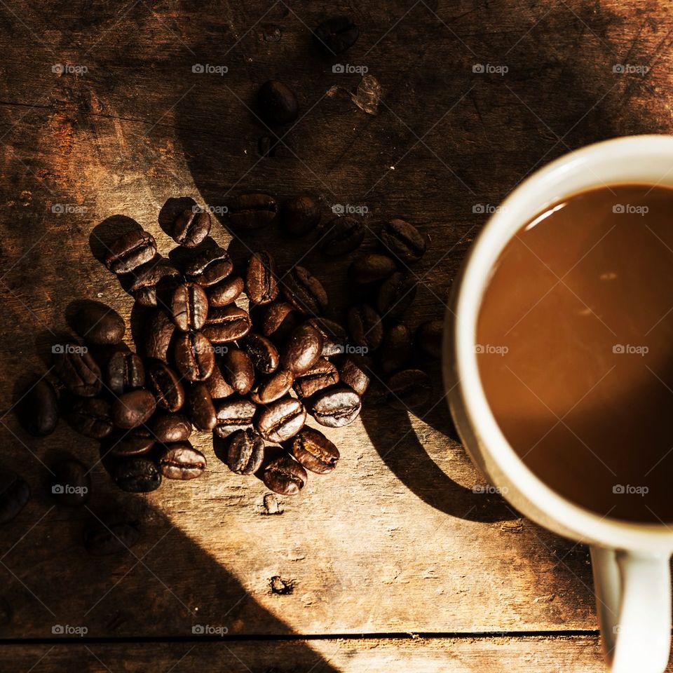 ACup of Coffee and beans on grunge wooden background with natural