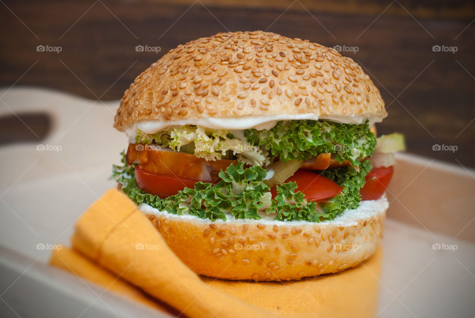 Close up hamburger chicken meat. Orange napkin. Healthy homemade fast food concept