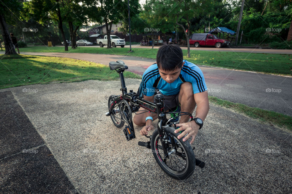 Man fixing the bike in the public park