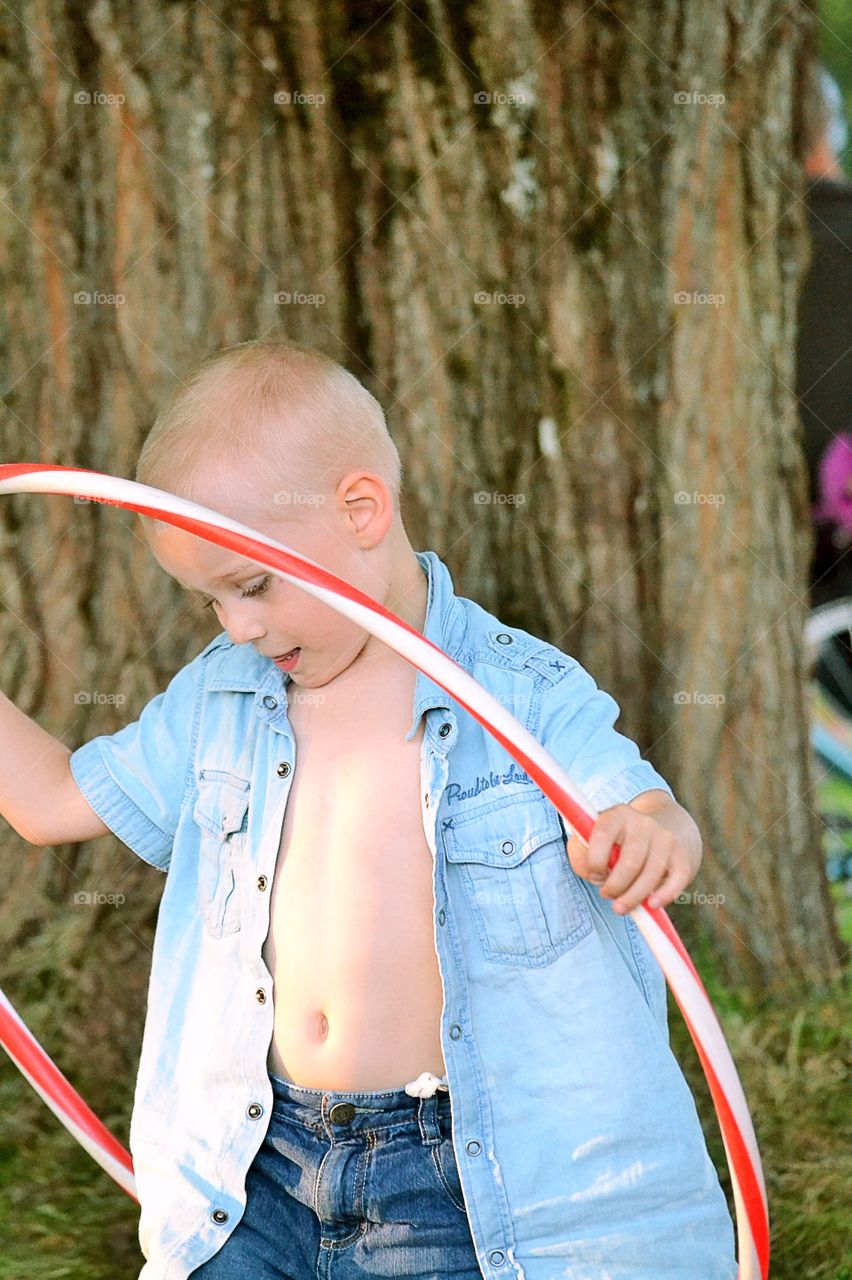 Boy plays. Boy with an hula hoop