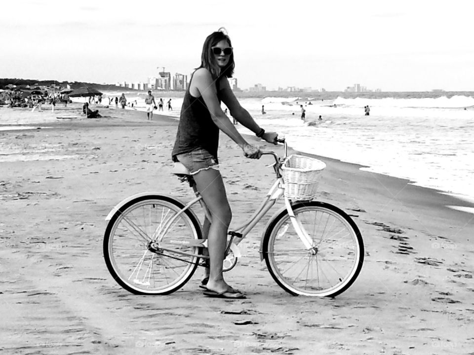 Woman on a bicycle on the beach shore