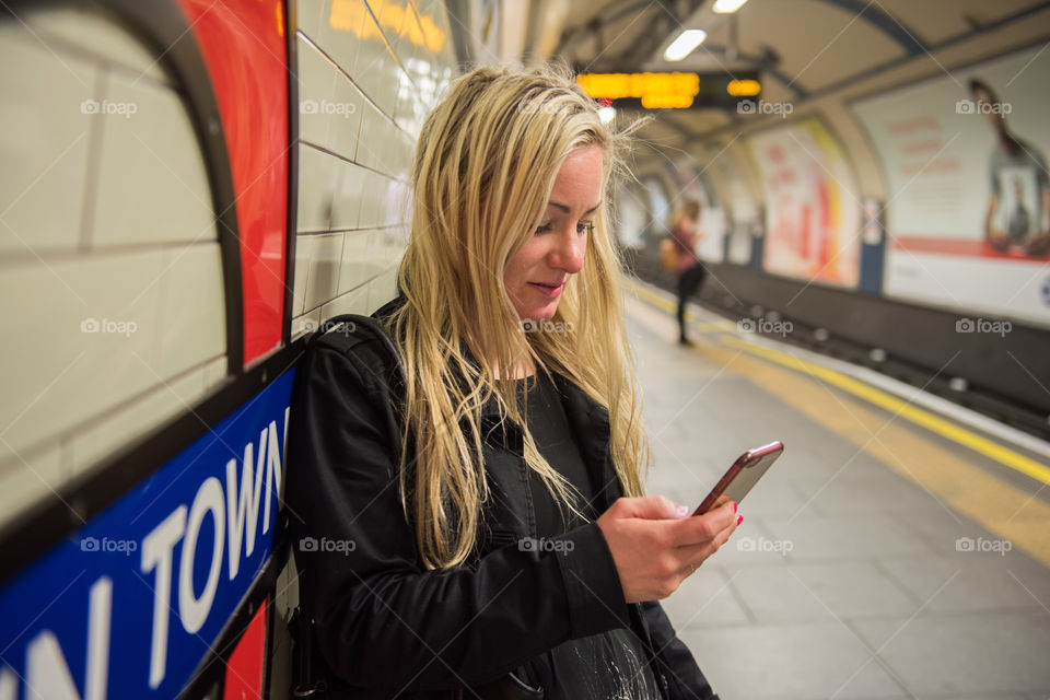 Woman using mobile phone in subway station