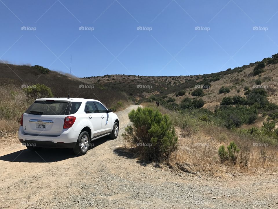 One white can parked in desert 